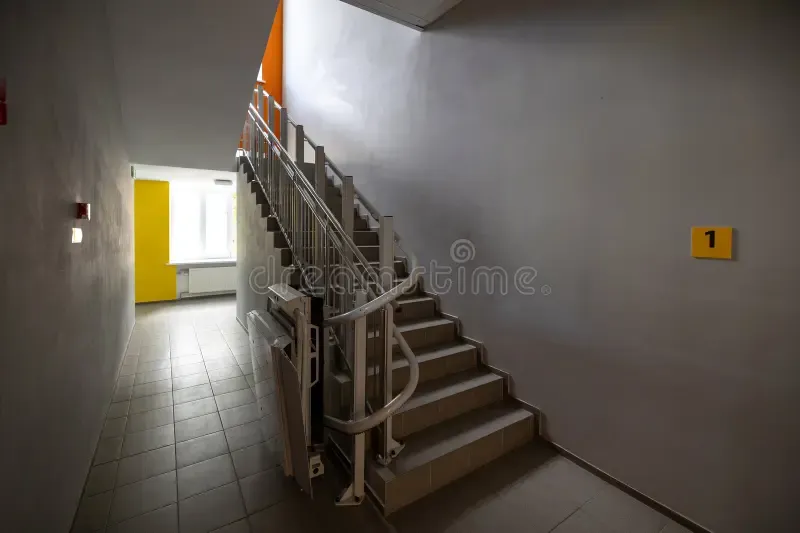 Stairlift rail fitted beside a flight of steps, as used for outdoor and communal stairs